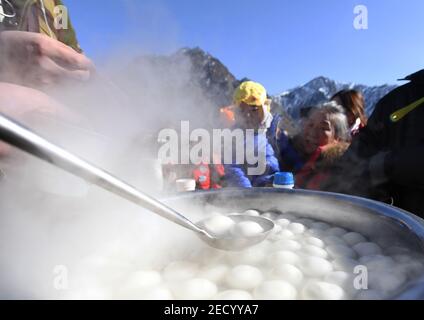 (210214) -- BEIJING, le 14 février 2021 (Xinhua) -- les touristes attendent d'être servis avec des boulettes de farine de riz bouillies, gourmandes, typiquement consommées à la fin des vacances du nouvel an lunaire, dans le parc national Tianshan Tianchi, dans la région autonome de Xinjiang, dans le nord-ouest de la Chine, le 17 février 2021. Le nouvel an lunaire figure parmi les festivals les plus importants de Chine, et les célébrations sont multiples, y compris la nourriture. Quand le nouvel an lunaire viendra, les Chinois font une variété de collations qui, selon eux, apporteront une bonne fortune. (Xinhua/Sadat) Banque D'Images