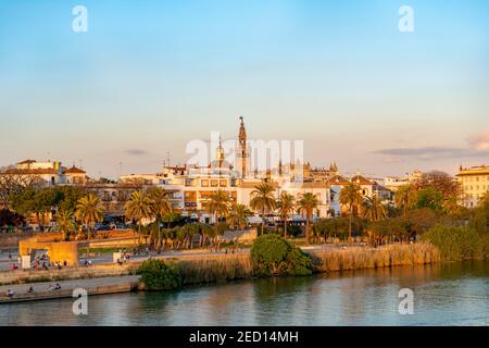 Vue sur la rivière Rio Guadalquivir jusqu'à la place de la tauromachie De toros de la Real Maestranza de Caballeria de Sevilla Et le clocher de la Giralda Banque D'Images