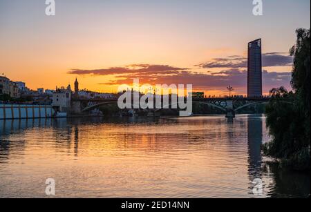 Pont Puente de Triana au-dessus de la rivière Rio Guadalquivir, dans le gratte-ciel arrière Torre Sevilla, coucher de soleil, Séville, Andalousie, Espagne Banque D'Images