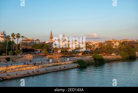 Front de mer Muelle de la sal au fleuve Rio Guadalquivir avec Monumento a la Tolerancia, dans le clocher arrière la Giralda, coucher de soleil, Séville Banque D'Images