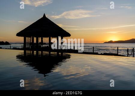 Belvédère au coucher du soleil au bord de la piscine, le domaine de l'Orangeraie Resort, la Digue, Seychelles Banque D'Images