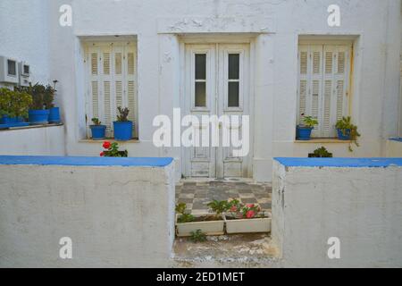 Ancienne maison rurale traditionnelle avec murs blanchis à la chaux et porte en bois blanc et volets à Chora, la capitale de l'île d'Andros dans les Cyclades, Grèce. Banque D'Images