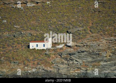 Paysage avec vue panoramique sur Aghios Ermolaos une église grecque orthodoxe perchée sur les rochers de Chora dans l'île d'Andros, Cyclades Grèce. Banque D'Images