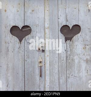 Deux formes de coeur sur la porte en bois antique représentant l'arrière-plan pour Amour - France Banque D'Images