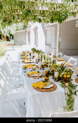 Haut angle de table élégante servi avec des compositions de citrons et vaisselle vide préparée pour banquet dans le jardin d'été Banque D'Images