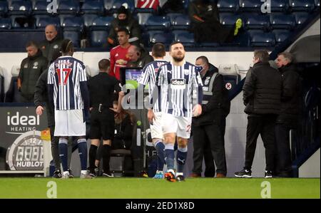 L'arbitre Craig Pawson consulte le contrôleur VAR du terrain avant de renverser une décision de pénalité donnée à Manchester United lors du match de la Premier League aux Hawthorns, West Bromwich. Date de la photo: Dimanche 14 février 2021. Banque D'Images