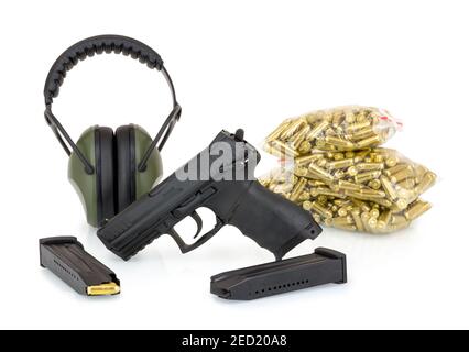 Pistolet, protections auditives et munitions. Isolé sur fond blanc avec réflexion d'ombre. Pistolet, casque antibruit, magazines et balles 9 mm empilés dans des sacs o Banque D'Images