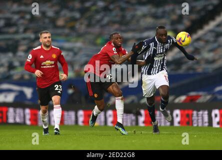 Aaron WAN-Bissaka de Manchester United (au centre) et Mbaye Diagne de West Bromwich Albion (à droite) se battent pour le ballon lors du match de la Premier League aux Hawthorns, West Bromwich. Date de la photo: Dimanche 14 février 2021. Banque D'Images