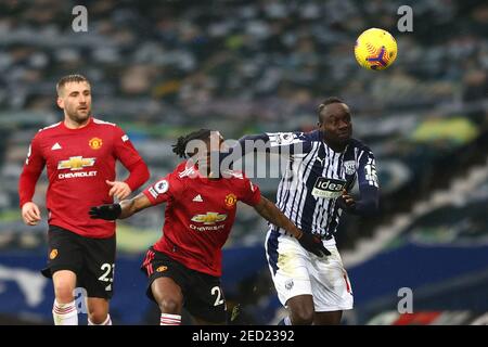 Aaron WAN-Bissaka de Manchester United (au centre) et Mbaye Diagne de West Bromwich Albion (à droite) se battent pour le ballon lors du match de la Premier League aux Hawthorns, West Bromwich. Date de la photo: Dimanche 14 février 2021. Banque D'Images