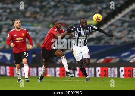 Aaron WAN-Bissaka de Manchester United (au centre) et Mbaye Diagne de West Bromwich Albion (à droite) se battent pour le ballon lors du match de la Premier League aux Hawthorns, West Bromwich. Date de la photo: Dimanche 14 février 2021. Banque D'Images