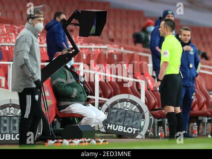 Stuart Attwell, arbitre de match, consulte le VAR pour vérifier s'il faut accorder une pénalité lors du match de la Premier League à l'Emirates Stadium, Londres. Date de la photo: Dimanche 14 février 2021. Banque D'Images