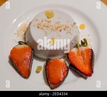 Assiette à dessert raffinée : panna cotta à la noix de coco, gel d'ananas et fraises enrobées de chocolat par le chef Paul Wedgwood, Écosse, Royaume-Uni Banque D'Images