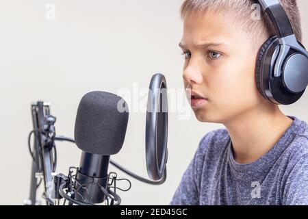 Un garçon portant un casque parle avec un jeu de microphones apprentissage en ligne, enseignement à distance, jeux, podcast Banque D'Images