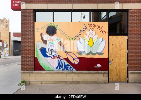 Peinture murale montrant une personne pagayant un canoë sur des planches couvrir les fenêtres du magasin pendant les troubles civils après le meurtre De George Floyd à Minneapo Banque D'Images