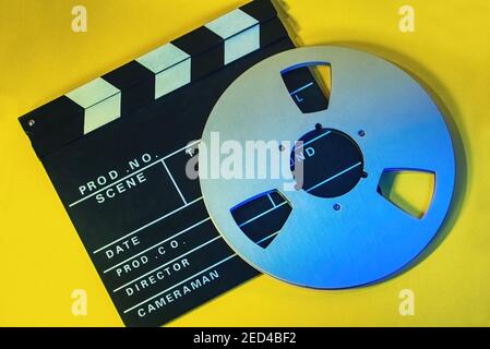 photo plein format d'une carte de film et d'une bobine de bande sur fond jaune. Un cinéma, un concept de cinéma Banque D'Images