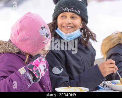 Helsinki Finlande 14 février 2021. Compagnie d'enfants qui mangent de la soupe dans la rue. Photo de haute qualité Banque D'Images