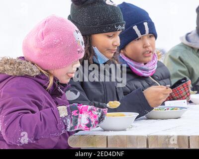 Helsinki Finlande 14 février 2021. Compagnie d'enfants qui mangent de la soupe dans la rue. Photo de haute qualité Banque D'Images