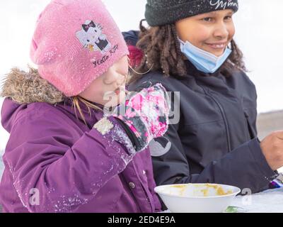 Helsinki Finlande 14 février 2021. Compagnie d'enfants qui mangent de la soupe dans la rue. Photo de haute qualité Banque D'Images