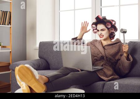 Une femme en colère assise sur un canapé avec un ordinateur portable et un logiciel ou problème de connexion wifi Banque D'Images