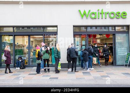 Une file d'attente de personnes portant des masques de visage file d'attente pour entrer dans Waitrose pendant le verrouillage, 2021 Banque D'Images