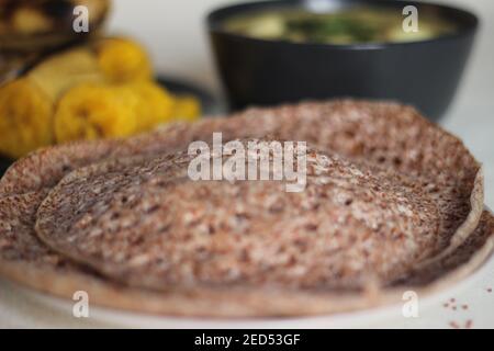 Des trémies faites de millet à doigts servies avec un ragoût d'œufs préparé dans le style du Kerala et du plantain chauffé à la vapeur. Prise de vue sur fond blanc Banque D'Images