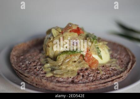 Des trémies faites de millet à doigts servies avec un ragoût d'oeufs préparé dans le style du Kerala. Prise de vue sur fond blanc Banque D'Images