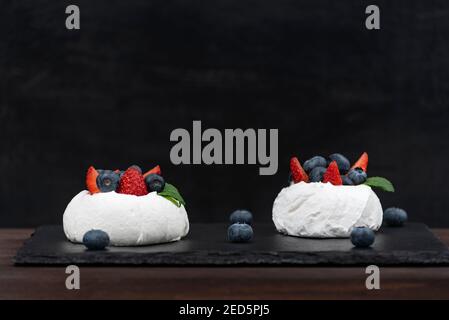 Gateau Anna Pavlova Sur Fond Noir Ajoutez Du Gateau A La Meringue Aux Fraises Fraiches Et Aux Bleuets Photo Stock Alamy