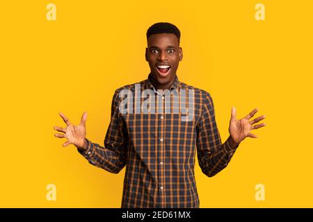 Portrait d'un homme afro-américain joyeux qui se soulève la main dans l'excitation Banque D'Images