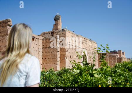 Jeune femme blonde touriste observant des cigognes sur un toit dedans Marrakech Banque D'Images