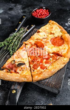 Ensemble de différentes tranches de pizza. Arrière-plan noir. Vue de dessus Banque D'Images