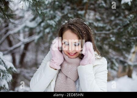Femme regarde vers le bas et des kilomètres sous l'arbre recouvert de neige Banque D'Images