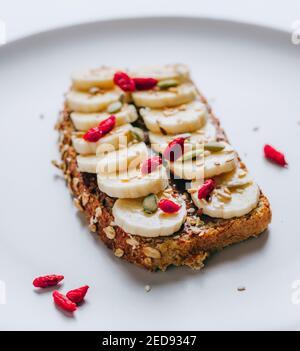 Pain grillé au chocolat au beurre d'arachide, à la banane, à la citrouille, aux graines de tournesol et de lin, au sésame et aux baies de goji. Copier l'espace Banque D'Images