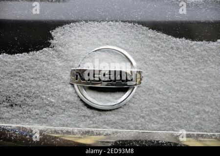 Logo de voiture Nissan sur le couvercle du coffre sous une couche de neige. Banque D'Images