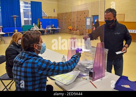 Un homme portant un masque projette son vote électoral dans les urnes lors des élections régionales catalanes. Aujourd'hui, la Catalogne va aux urnes pour voter pour le président du gouvernement de la Catalogne en vertu de mesures strictes de sécurité sanitaire en raison de la crise de la pandémie de Covid-19. Les patients positifs de Covid19 ont droit à une allocation pour voter entre 7 h 00 et 8 h 00 Banque D'Images
