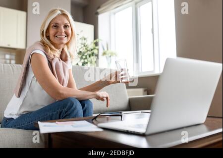 Une femme adulte suit un mode de vie sain. Occupée femme d'affaires réussie prenant une pause de travail à distance ou d'apprentissage, de boire de l'eau tout en travaillant ou d'étudier le processus Banque D'Images