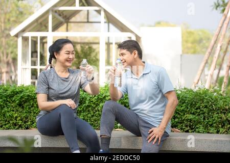 L'Asie d'âge moyen boit de l'eau après l'entraînement sportif dans concept couple famille retraite liberté finance assurance vie Banque D'Images