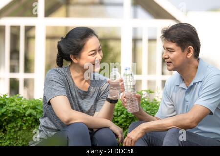 L'Asie d'âge moyen boit de l'eau après l'entraînement sportif dans concept couple famille retraite liberté finance assurance vie Banque D'Images