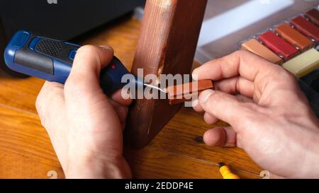 restauration réparation de la surface en bois sur les égratignures et les éclats d'étanchéité des meubles ensemble d'outils gros plan Banque D'Images