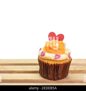 Joli cupcake, un gros plan de la boulangerie maison de gâteau au beurre crème avec garniture en forme de coeur rouge isolée sur fond blanc. Banque D'Images