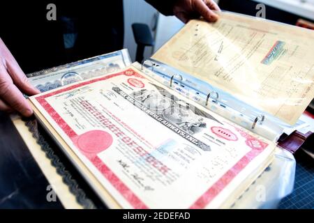 Hanovre, Allemagne. 11 février 2021. Jürgen Klotzsch, commis aux héritages de l'Etat à l'Office d'Etat pour le bâtiment et l'immobilier, passe par un dossier de parts historiques d'une collection que l'Etat de Basse-Saxe a reçue d'un domaine. Beaucoup de gens sont heureux quand ils héritent - mais pas tous ont un héritier. Si aucun héritier n'est désigné, les successions en Basse-Saxe tombent à l'état. Credit: Hauke-Christian Dittrich/dpa/Alay Live News Banque D'Images