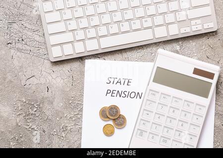 Pièces avec calculatrice, ordinateur et feuilles de papier avec texte ÉTAT PENSION sur fond grunge Banque D'Images