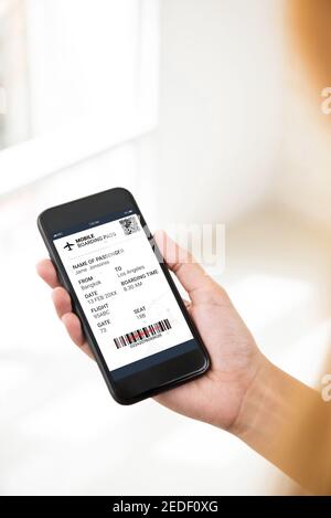 Le smartphone de la porte du passager vérifie les informations de voyage sur la carte d'embarquement électronique avant le vol Banque D'Images