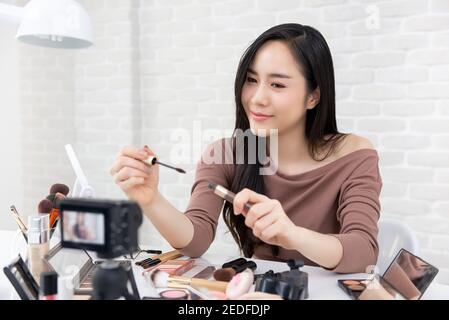 Belle femme asiatique professionnel de beauté enregistreur de vlogger maquillage cosmétique tutoriel vidéo à partager sur les réseaux sociaux Banque D'Images