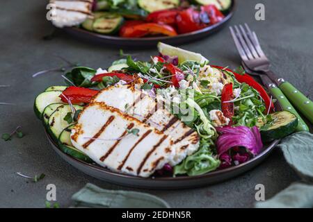 Fromage halloumi grillé avec légumes grillés et salade verte, fond en béton vert. Concept d'alimentation saine. Mise au point sélective. Banque D'Images