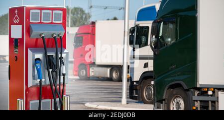 Poste de charge de véhicules électriques sur fond d'une rangée de camions. Concept Banque D'Images