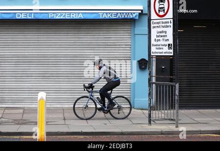 Photo du dossier datée du 26/12/2020 d'un cycliste qui fait le maximum des rues désertes du centre-ville de Belfast. Plus d'un tiers des chefs d'entreprise pensent que le gouvernement n'a pas suffisamment fait pour aider les entreprises à traverser la pandémie dans un « appel fort à l'aide » de la part des entreprises britanniques, a révélé une étude. Date de publication : lundi 15 février 2021. Banque D'Images