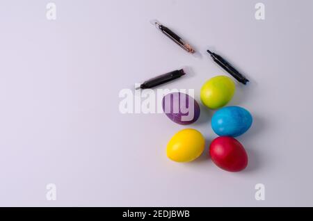 Arrière-plan de Pâques. Les œufs de poulet peints en jaune, vert, bleu, rouge et violet se trouvent sur un fond clair. Étape 5 Banque D'Images