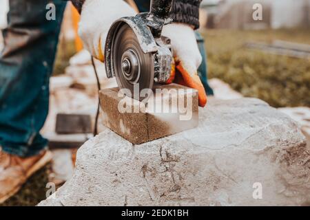 La lame diamant du moulin coupe rapidement et avec précision le bloc de béton - la coupe de carreaux de pierre pour le trottoir Banque D'Images