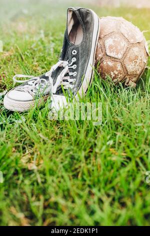 Baskets et ballon de football déchirés - joueur de football d'époque tenue Banque D'Images