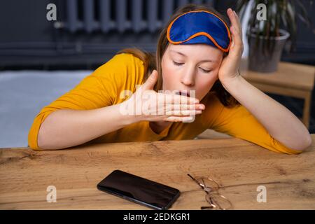 La femme endormie couchée à l'étage tard dans la nuit ne peut pas dormir. Insomnie, nomophobie, notion de trouble du sommeil. Dépendance sur les réseaux sociaux. Banque D'Images